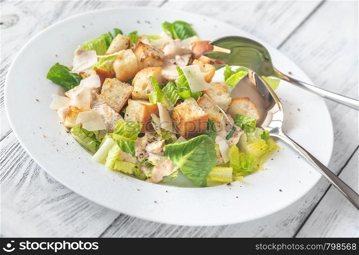 Portion of Caesar salad on the wooden table