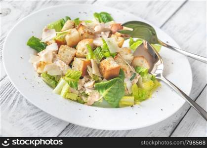 Portion of Caesar salad on the wooden table
