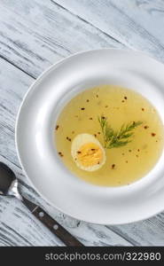 Portion of chicken stock on the wooden table