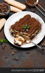 portion of Classic tiramisu dessert and savoiardi cookies on concrete background or table. portion of Classic tiramisu dessert and savoiardi cookies on concrete background