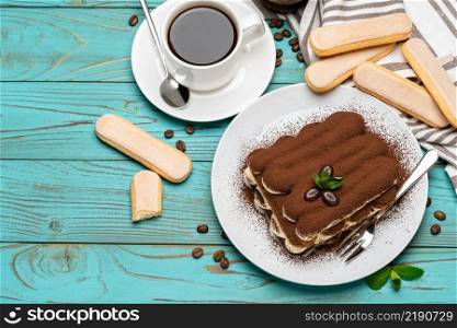portion of Classic tiramisu dessert, cup of coffee and savoiardi cookies on wooden background or table. portion of Classic tiramisu dessert, cup of coffee and savoiardi cookies on wooden background