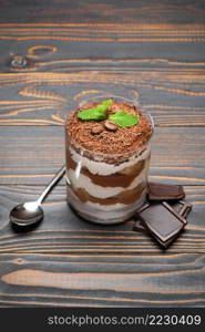 portion of Classic tiramisu dessert in a glass on wooden background or table. portion of Classic tiramisu dessert in a glass on wooden background