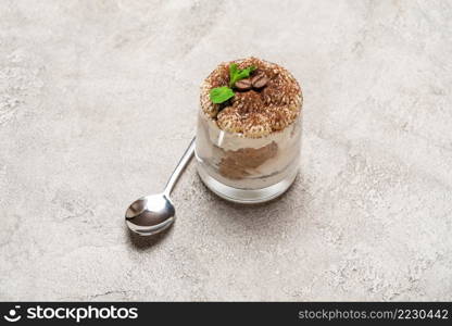 portion of Classic tiramisu dessert in a glass on wooden concrete or table. portion of Classic tiramisu dessert in a glass on concrete background