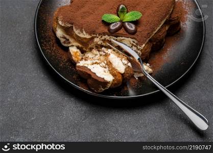 portion of Classic tiramisu dessert on ceramic plate on concrete background or table. portion of Classic tiramisu dessert on ceramic plate on concrete background
