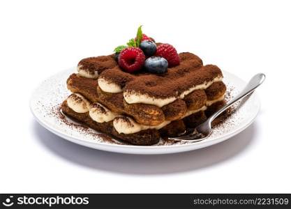 portion of Classic tiramisu dessert with raspberries and blueberries on ceramic plate isolated on white background - clipping path embedded. portion of Classic tiramisu dessert with raspberries and blueberries on ceramic plate isolated on white background - clipping path