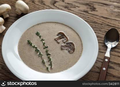 Portion of creamy mushroom soup on the wooden table