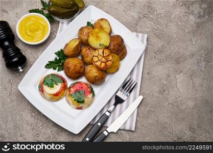 Portion of delicious chicken aspic and baked potato on a plate on concrete table. High quality photo. Portion of delicious chicken aspic and baked potato on a plate on concrete table