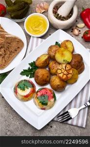 Portion of delicious chicken aspic and baked potato on a plate on concrete table. High quality photo. Portion of delicious chicken aspic and baked potato on a plate on concrete table