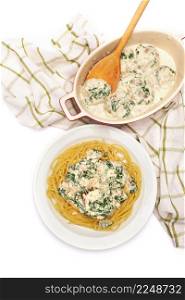 Portion of delicious meatballs with spinach in a creamy sauce and pasta. High quality photo. Portion of delicious meatballs with spinach in a creamy sauce and pasta