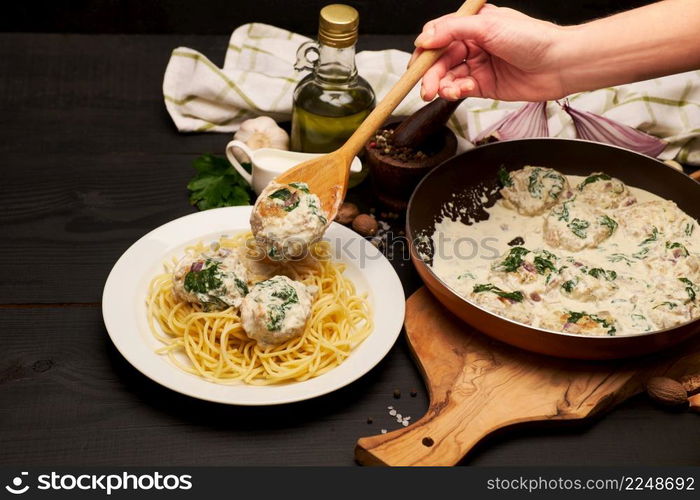 Portion of delicious meatballs with spinach in a creamy sauce. High quality photo. Portion of delicious meatballs with spinach in a creamy sauce