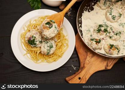 Portion of delicious meatballs with spinach in a creamy sauce. High quality photo. Portion of delicious meatballs with spinach in a creamy sauce