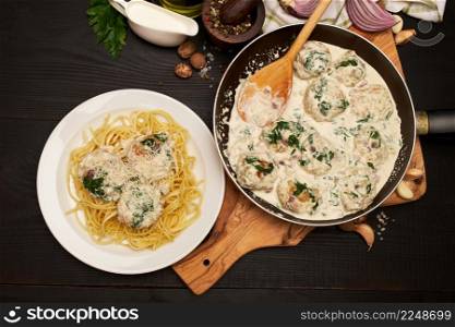Portion of delicious meatballs with spinach in a creamy sauce. High quality photo. Portion of delicious meatballs with spinach in a creamy sauce