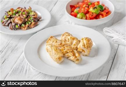 Portion of fried calamari with shiitake mushrooms and tomato salad