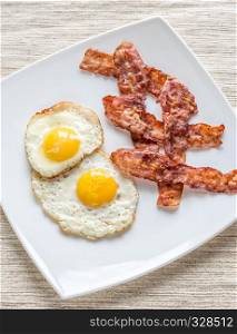 Portion of fried eggs with bacon