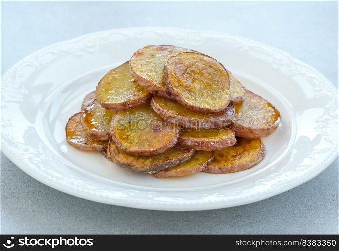 Portion of fried sliced potatoes on the plate
