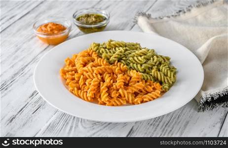 Portion of fusilli pasta with traditional and tomato pesto