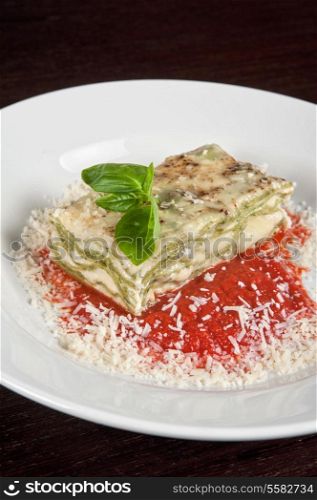 Portion of lasagna garnished with salad greens