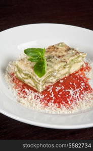 Portion of lasagna garnished with salad greens