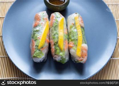 portion of Nem Cuon, Vietnamese fresh spring rolls close up on gray blue plate