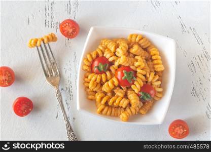 Portion of pasta with tomato and ricotta pesto on the white table