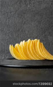 Portion of potato chips on the dark background