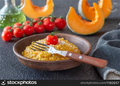 Portion of pumpkin risotto decorated with cherry tomato