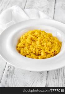 Portion of saffron risotto on the wooden table