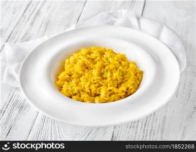 Portion of saffron risotto on the wooden table