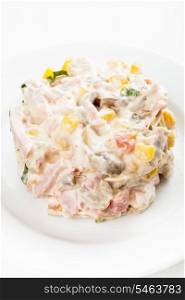 Portion of salad with ham, meat, mushrooms, vegetables and mayonnaise