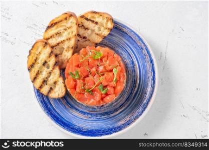 Portion of salmon avocado tartare with grilled bread