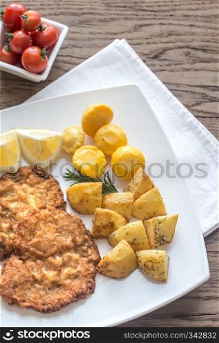 Portion of schnitzel with garnish on the wooden table