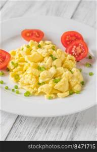 Portion of Scrambled eggs with tomatoes on the plate