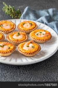 Portion of shrimp tartlets with cheesy sauce