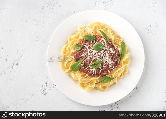 Portion of tagliatelle with bolognese sauce on the table