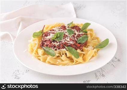 Portion of tagliatelle with bolognese sauce on the table