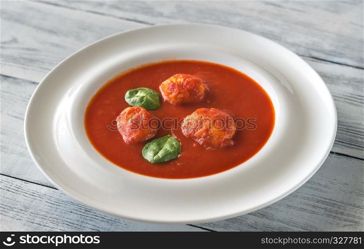 Portion of tomato soup with meatballs