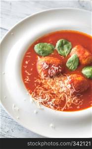 Portion of tomato soup with meatballs