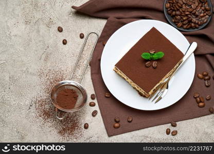 Portion of Traditional Italian Tiramisu dessert and coffee beans on grey concrete background.. Portion of Traditional Italian Tiramisu dessert and coffee beans on grey concrete background