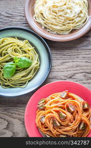 Portions of colorful spaghetti with ingredients