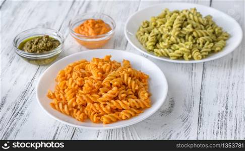 Portions of fusilli with traditional and tomato pesto
