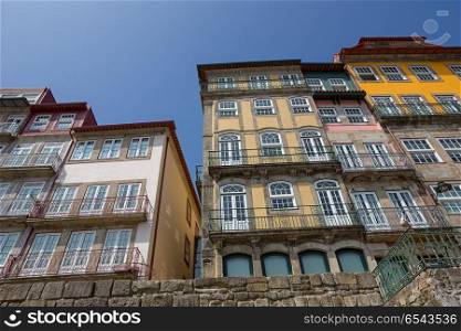 Porto, Portugal. April 17, 2017: The typical colorful buildings of the Ribeira District with shops, restaurants and bars built in the stone wall. Unesco World Heritage Site.. Porto