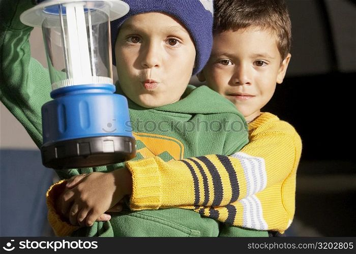 Portrait a boy hugging his friend and holding a lantern