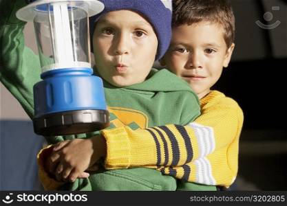 Portrait a boy hugging his friend and holding a lantern