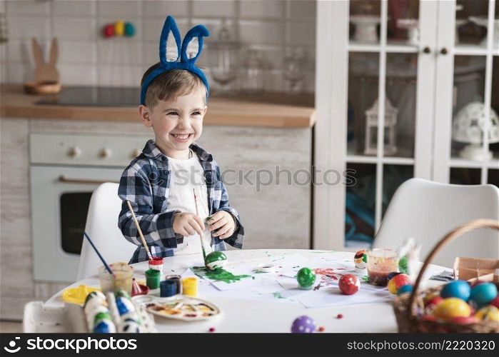 portrait adorable little boy painting eggs easter