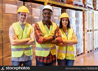 Portrait african black warehouse supervisor stand and crossed his arms with his interracial team in large warehouse distribution center. Business warehouse inventory logistic and teamwork concept