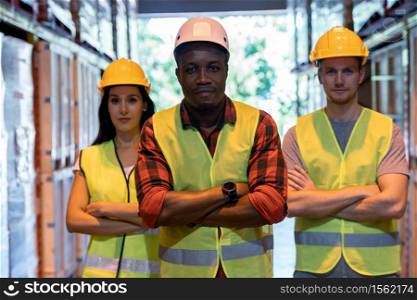 Portrait african black warehouse supervisor stand and crossed his arms with his interracial team in large warehouse distribution center. Business warehouse inventory logistic and teamwork concept