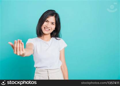 Portrait Asian beautiful happy young woman smile wear white t-shirt standing making gesture with hand inviting to come confidently, on a blue background with copy space