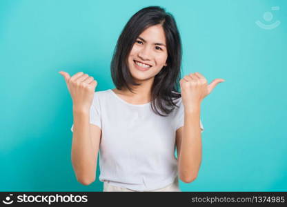 Portrait Asian beautiful happy young woman smile white teeth wear white t-shirt standing successful woman giving two thumbs up gesture, on a blue background with copy space