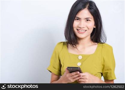 Portrait Asian beautiful happy young woman standing smile holding using mobile smart phone looking to camera, shoot the photo in a studio on a white background, There was copy space
