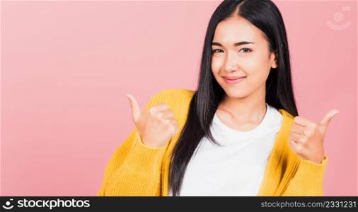 Portrait Asian beautiful young woman smile she standing made finger thumbs up, Ok sign to agree studio shot isolated on pink background, Thai female successful like finger gesture with copy space